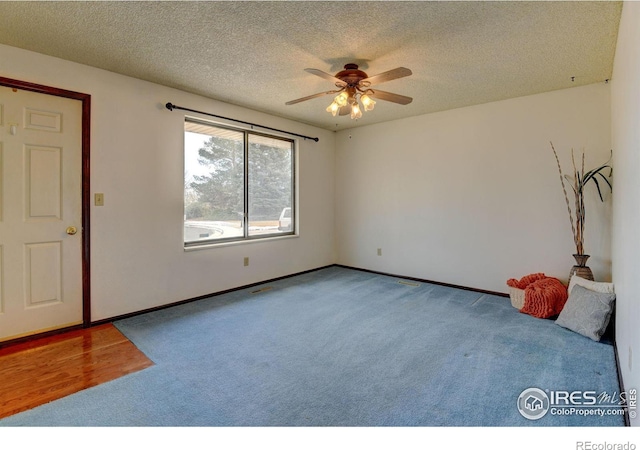 spare room featuring a textured ceiling, carpet floors, and ceiling fan