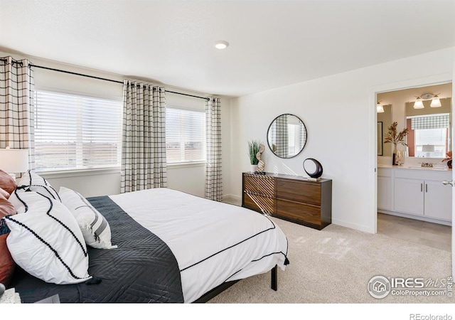 bedroom featuring sink, light colored carpet, and connected bathroom