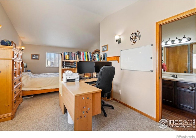 carpeted bedroom with sink, ensuite bathroom, and lofted ceiling