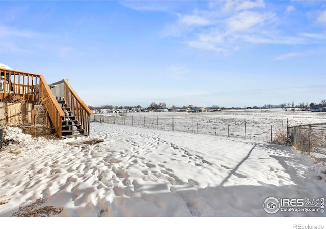 snowy yard with a rural view