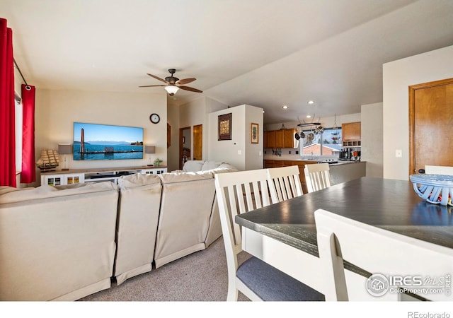 living room featuring light colored carpet, vaulted ceiling, and ceiling fan