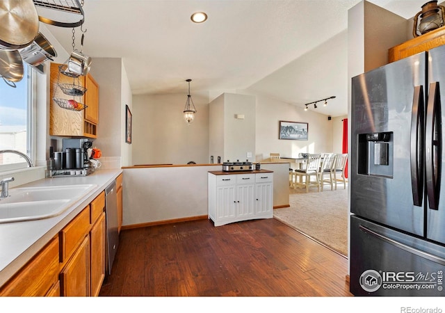 kitchen with pendant lighting, vaulted ceiling, sink, dark wood-type flooring, and stainless steel appliances