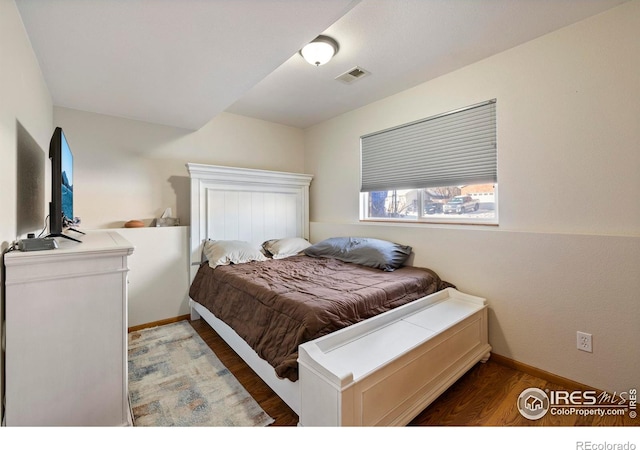 bedroom with dark wood-type flooring