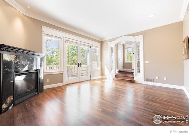 unfurnished living room featuring french doors, dark hardwood / wood-style flooring, crown molding, and a fireplace