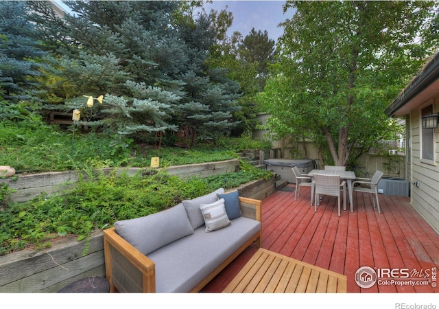 wooden terrace with a hot tub and an outdoor hangout area