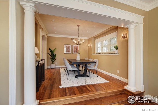 dining room featuring hardwood / wood-style floors, decorative columns, and ornamental molding