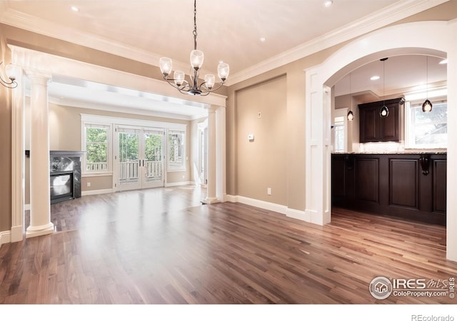 interior space with ornamental molding, light hardwood / wood-style flooring, ornate columns, and an inviting chandelier