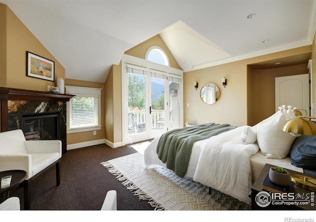 bedroom featuring dark carpet, a premium fireplace, lofted ceiling, and access to outside