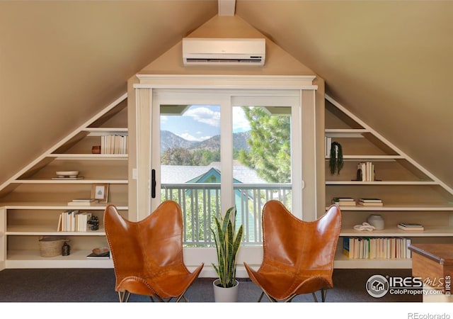 sitting room featuring built in shelves, a mountain view, carpet flooring, and a wall unit AC