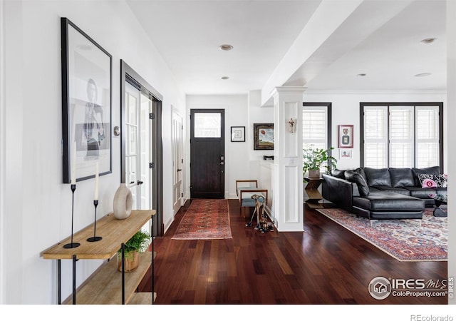 entryway featuring decorative columns and dark hardwood / wood-style flooring