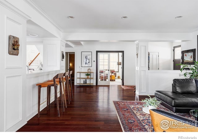 living room with dark hardwood / wood-style floors and ornamental molding