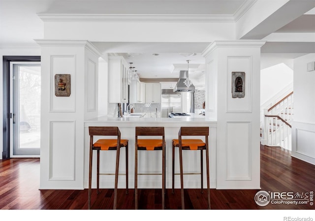 kitchen featuring a kitchen bar, white cabinetry, and kitchen peninsula