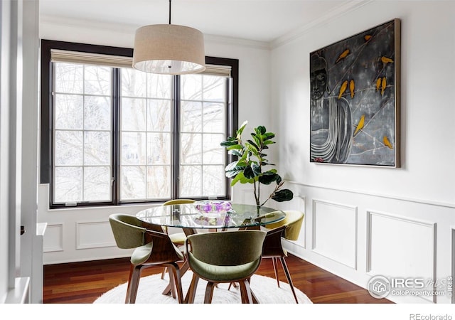 dining space featuring dark hardwood / wood-style flooring, ornamental molding, and a healthy amount of sunlight