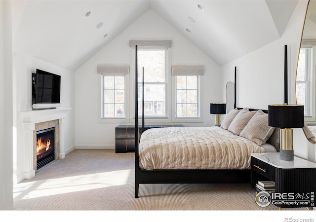 bedroom with light colored carpet and lofted ceiling