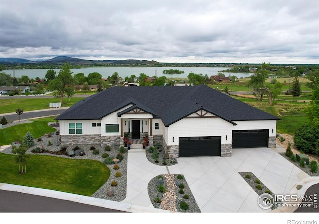 view of front facade with a garage and a water and mountain view