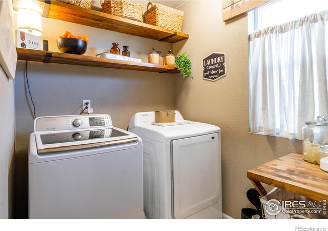 clothes washing area with washer and clothes dryer