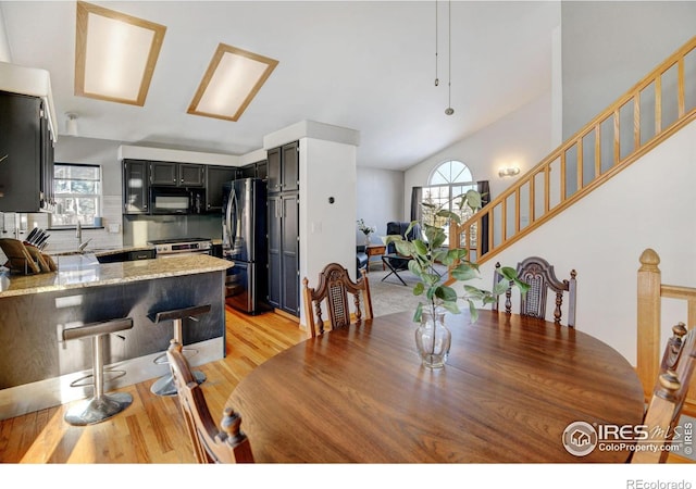 dining area featuring light wood finished floors and stairs