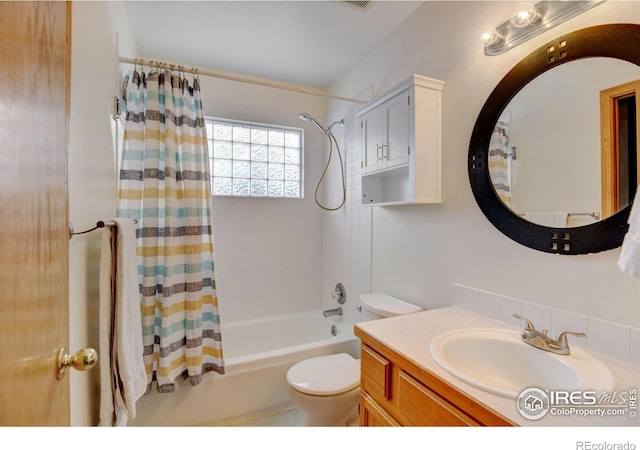 bathroom featuring shower / bath combination with curtain, vanity, and toilet