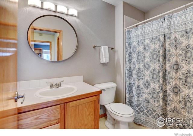 bathroom featuring a shower with curtain, vanity, and toilet