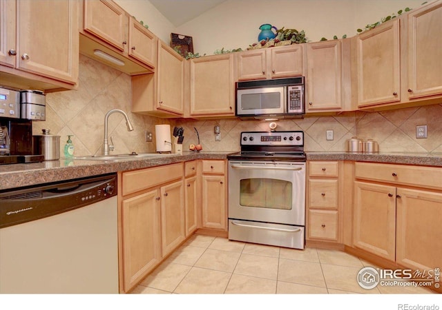 kitchen with light brown cabinets, appliances with stainless steel finishes, and a sink