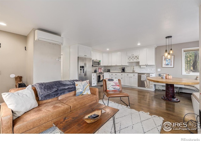 living room featuring sink, hardwood / wood-style floors, and a wall mounted air conditioner