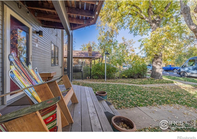 deck with a lawn and fence