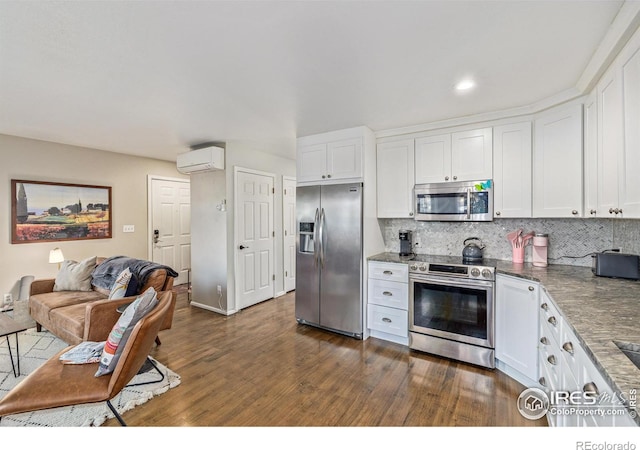 kitchen with backsplash, a wall mounted air conditioner, white cabinetry, and appliances with stainless steel finishes