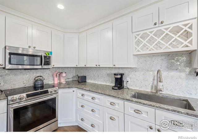 kitchen featuring white cabinetry, tasteful backsplash, appliances with stainless steel finishes, and a sink