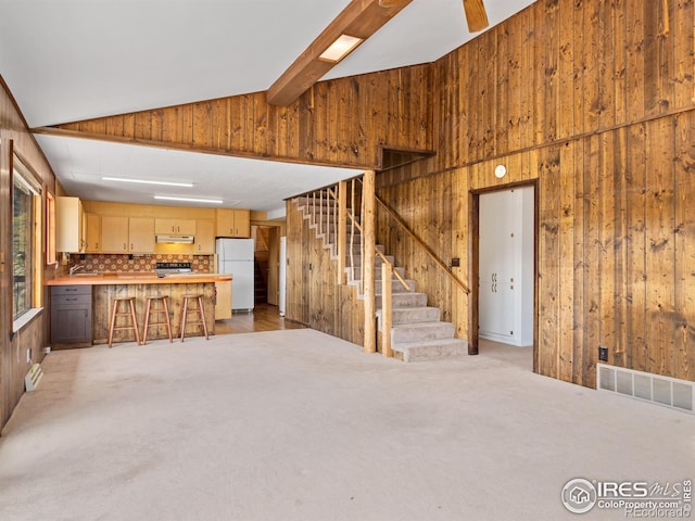 unfurnished living room with light colored carpet and lofted ceiling