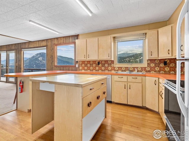 kitchen with a mountain view, light brown cabinetry, a center island, and range with electric cooktop