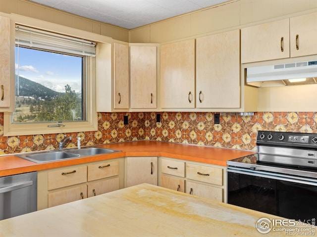 kitchen with sink, stainless steel appliances, light brown cabinetry, and a mountain view