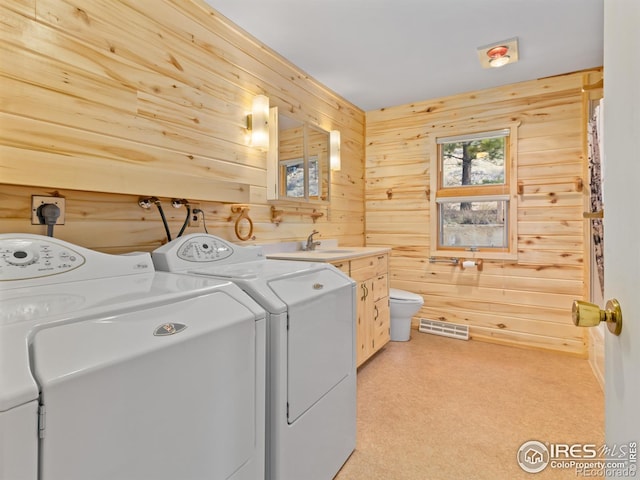 washroom featuring wood walls and separate washer and dryer