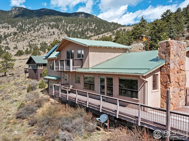 rear view of property featuring a deck with mountain view