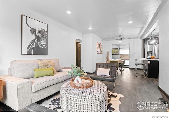 living room featuring ceiling fan and dark hardwood / wood-style floors