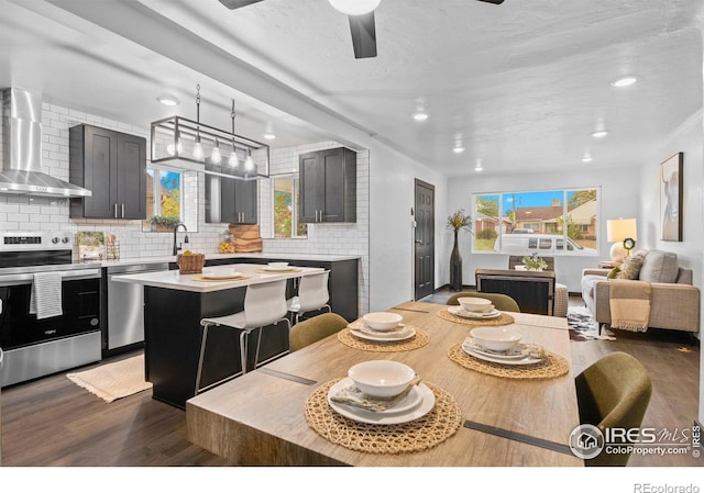 dining area with ceiling fan, sink, a wealth of natural light, and dark hardwood / wood-style flooring