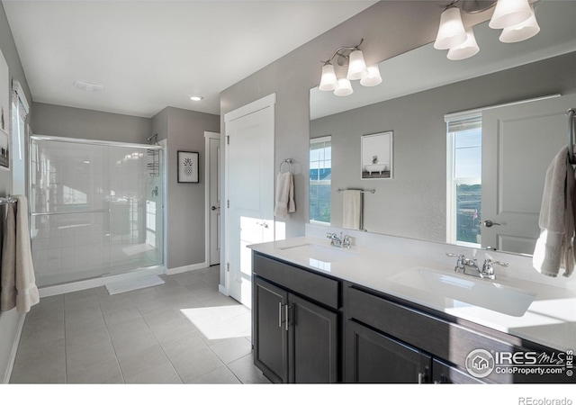 bathroom featuring a wealth of natural light, an enclosed shower, vanity, and tile patterned flooring