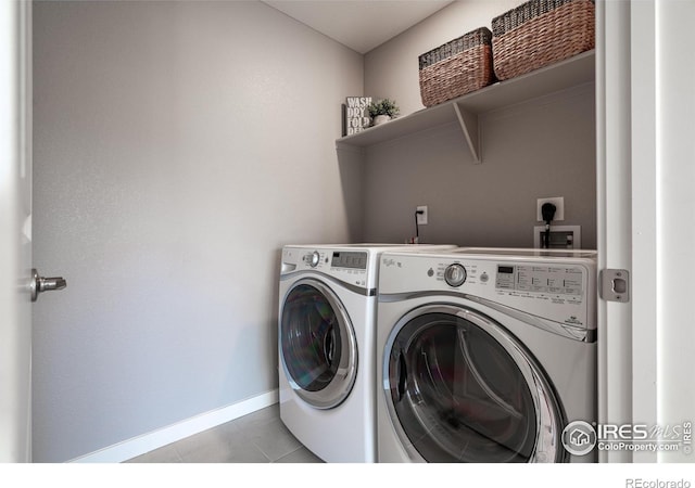 washroom with light tile patterned floors and washer and dryer