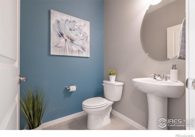 bathroom featuring sink, toilet, and tile patterned flooring