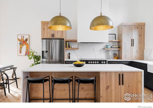 kitchen featuring a breakfast bar area, a center island, stainless steel fridge with ice dispenser, hanging light fixtures, and decorative backsplash