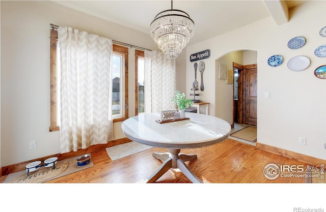 dining area featuring hardwood / wood-style flooring and a notable chandelier