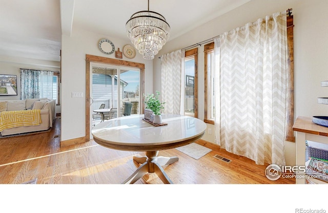 dining room featuring light hardwood / wood-style floors, an inviting chandelier, and a healthy amount of sunlight