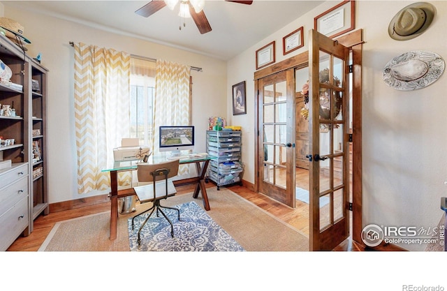 home office with light hardwood / wood-style floors, ceiling fan, and french doors