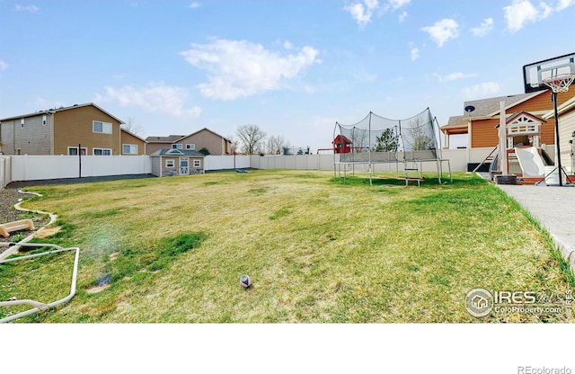 view of yard with a storage unit and a trampoline