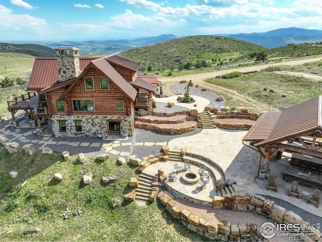 exterior space featuring a mountain view, a patio, and a fire pit