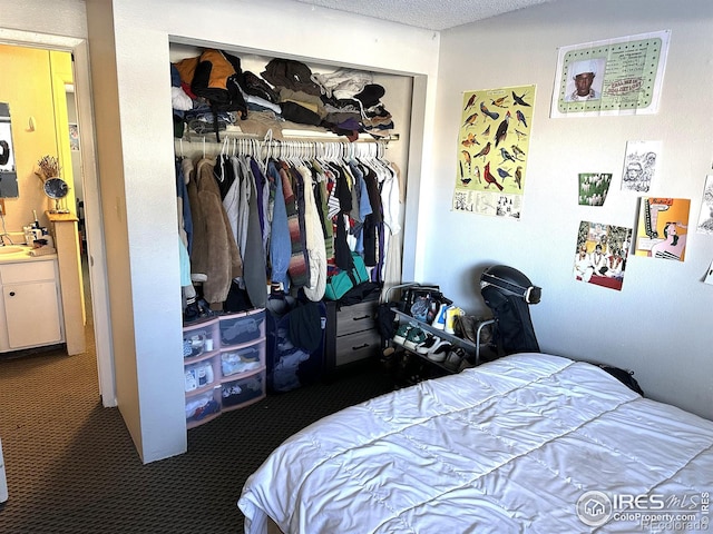 carpeted bedroom featuring a closet and a textured ceiling