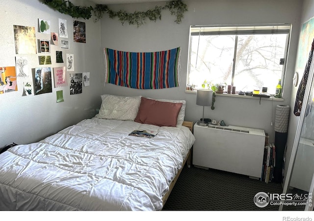 carpeted bedroom featuring radiator