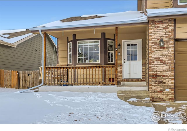 snow covered property entrance featuring covered porch