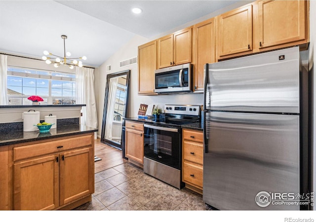 kitchen with lofted ceiling, appliances with stainless steel finishes, hanging light fixtures, dark stone counters, and a chandelier