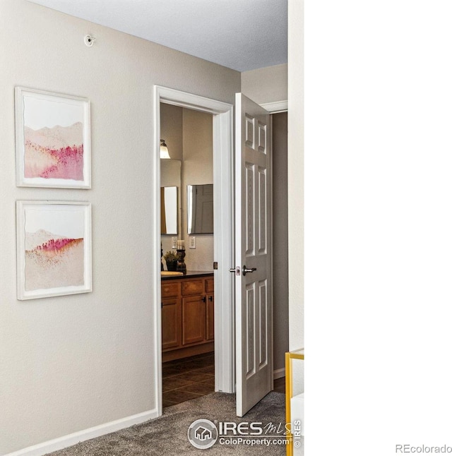 hallway featuring dark colored carpet