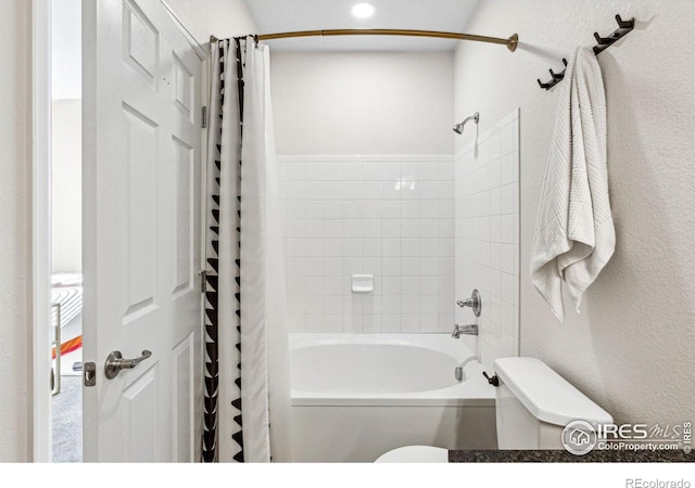 bathroom with toilet and shower / bath combo with shower curtain